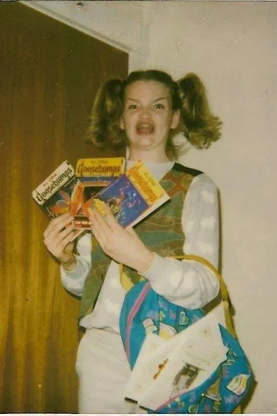 Original Ermahgerd meme photo — young Maggie Goldenberger holding three Goosebumps books with mouth open in exaggerated excitement, wearing a vest and pigtails